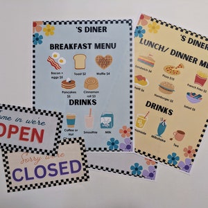 May include: A set of four signs for a diner, with a black and white checkered border. The signs are for breakfast, lunch, and dinner, and also indicate whether the diner is open or closed. The signs feature illustrations of food and drinks, including pancakes, waffles, sandwiches, pizza, hamburgers, and salad. The signs also include prices for each item.