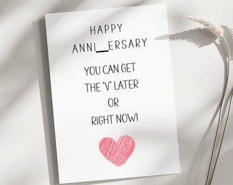 以下が含まれることがあります： 「Happy Anni_ersary You can get the "V" later or right now!」と書かれた白いカード。中央下部にピンク色のハートが描かれている。