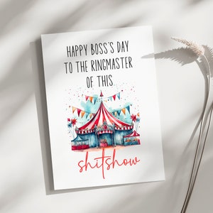 May include: A white greeting card with the text "HAPPY BOSS'S DAY TO THE RINGMASTER OF THIS shitshow". The card features a watercolour illustration of a circus tent with red and white stripes, blue accents, and colourful bunting.