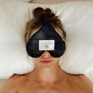May include: A black sleep mask with a white label that reads "mindful meditative" and "simple in sophistication".