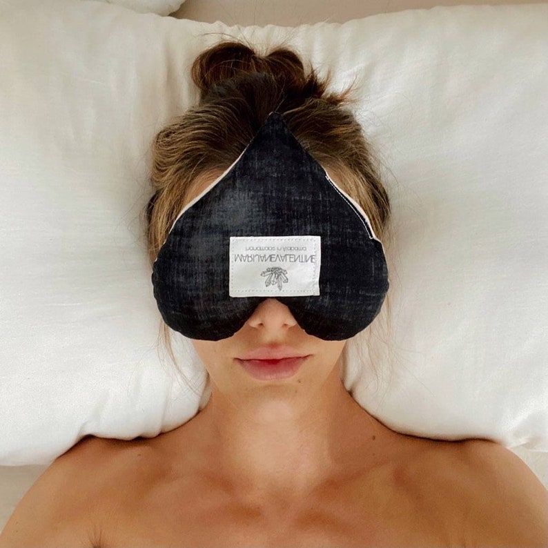 May include: A black sleep mask with a white label that reads "mindful meditative" and "simple in sophistication".