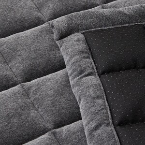 May include: A gray and black quilted throw blanket with a soft, plush texture. The blanket is made of two different fabrics, one with a smooth, woven texture and the other with a soft, fuzzy texture.