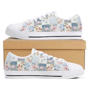 Könnte beinhalten: Weiße Canvas-Sneaker mit niedrigem Schaft und einem Patchwork-Design mit blauen und rosa Blumenmustern.