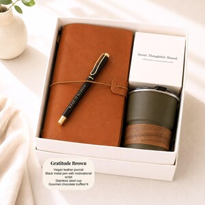 Pu&ograve; includere: Un set regalo in una scatola bianca include un diario in pelle vegana marrone, una penna nera con il testo "MAKE IT HAPPEN", una tazza in acciaio inossidabile e una carta con "Sweet. Thoughtful. Shared."