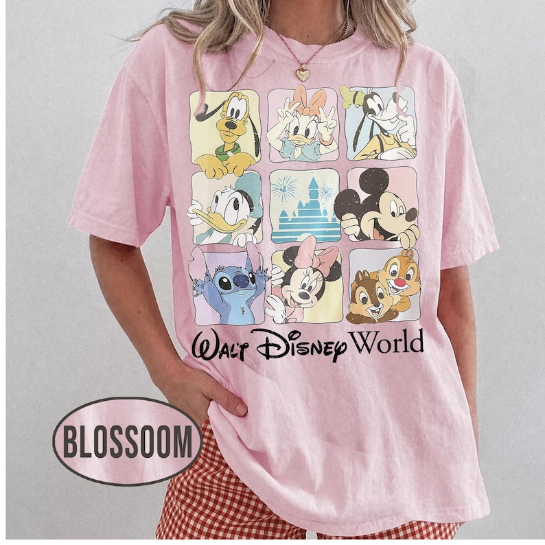 May include: A light pink short-sleeve t-shirt featuring a grid of nine squares with various Disney characters and a castle, including Pluto, Daisy, Goofy, Donald, Mickey, Stitch, Minnie, and Chip and Dale, with the text Walt Disney World below.