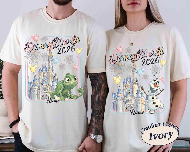 May include: Ivory-colored t-shirts with a Disney World 2026 design. One shirt features a green chameleon, the other Olaf the snowman, both in front of a castle. The design includes balloons and fireworks.
