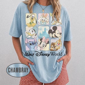 May include: A light blue t-shirt featuring a grid of nine squares with various cartoon characters including Pluto, Daisy Duck, Donald Duck, Mickey Mouse, Stitch, Minnie Mouse, and Chip 'n Dale, with the text Walt Disney World printed below.