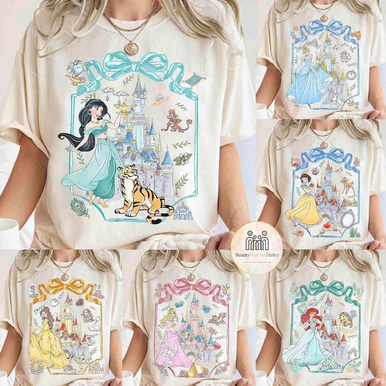 May include: Cream-colored t-shirts featuring various Disney princess designs. Each shirt showcases a princess, castle, and related imagery within a decorative frame. The princesses include Jasmine, Cinderella, Snow White, Belle, Aurora, and Ariel.