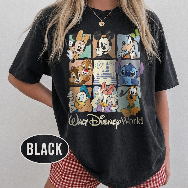 Op de afbeelding: Zwart T-shirt met een raster van Disney-personages, waaronder Mickey en Minnie Mouse, Goofy, Donald en Daisy Duck, Chip en Dale en Stitch. De tekst "Walt Disney World" staat eronder.