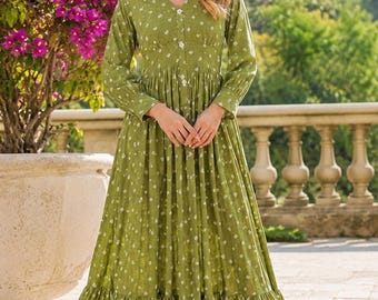 May include: A long-sleeved, floor-length olive green dress featuring a white floral pattern, a V-neckline, and a button-down front. The garment includes a fitted bodice with a gathered waistline and a tiered, ruffled hemline that flows to the floor.