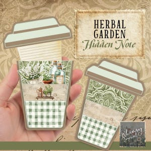 Op de afbeelding: Twee papieren journalkaarten in de vorm van een beker met een botanisch thema. Eén kaart wordt in een hand gehouden. De kaarten hebben een groen en wit geruit patroon, botanische illustraties en de tekst "HERBAL GARDEN Hidden Note."