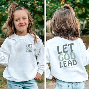 May include: A white sweatshirt featuring the text "LET GOD LEAD" in grey and green. The front of the sweatshirt has the text in a smaller size. The back of the sweatshirt has the text in a larger size, with "PROVERBS 3:5-6" below.