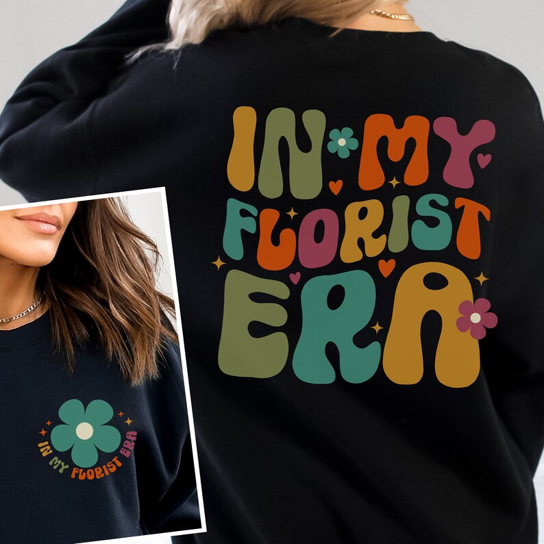 Op de afbeelding: Zwart sweatshirt met een retro-stijl grafische afbeelding die "In My Florist Era" zegt in kleurrijke, gestileerde letters. De afbeelding bevat een klein bloemetjesontwerp.