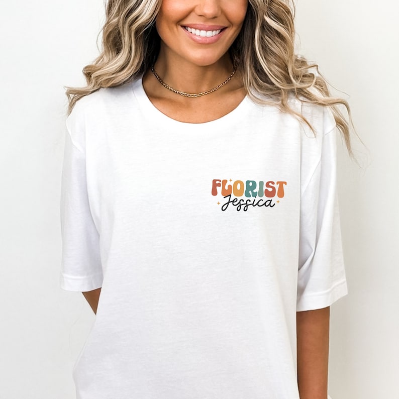 May include: White t-shirt with a colorful retro-style graphic that says "FLORIST Jessica".