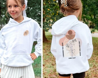 May include: White hoodie with a front pocket and a floral design. The back of the hoodie features the text "Consider the Lilies" and "And How They Grow" with a floral illustration and the Bible verse Luke 12:27.