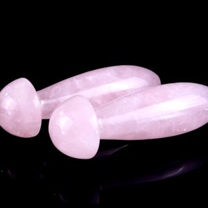 Puede incluir: Dos varitas de masaje de cuarzo rosa, una con un extremo redondeado y la otra con un extremo puntiagudo.