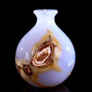 May include: A small, rounded vase with a light blue and brown patterned design. The vase has a narrow neck and a smooth, glossy finish. The brown pattern appears to be a natural inclusion within the material.
