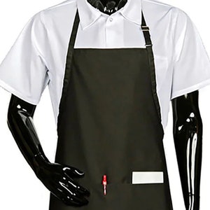 May include: A black apron with a white pocket and a red pen in the pocket. The apron has adjustable straps.