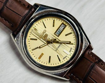Reloj automático vintage Seiko 5: esfera dorada, caja de acero inoxidable, fabricado en Japón.