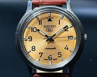 Reloj automático vintage Seiko 5: esfera dorada, caja de acero inoxidable, día/fecha