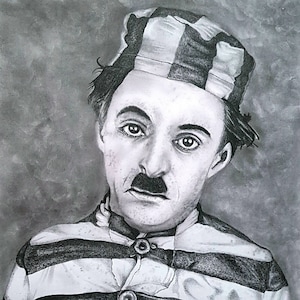 May include: Black and white pencil drawing of Charlie Chaplin in a striped prison uniform with the number 23 on the sleeve. The drawing is on a textured paper background.
