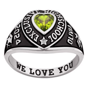 May include: A silver class ring with a black band and a heart-shaped green gemstone. The ring is inscribed with "EXCLUSIVE HIGH SCHOOL" and "2024". The words "WE LOVE YOU" are engraved on the band.