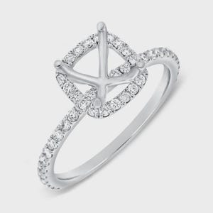 Könnte beinhalten: Ein silberner Ring mit quadratischem Halo-Design, besetzt mit kleinen, klaren Edelsteinen. Das Band ist ebenfalls mit ähnlichen Edelsteinen besetzt, was einen funkelnden Effekt erzeugt. Der Mittelteil des Rings ist für einen größeren Edelstein vorgesehen.