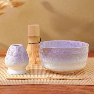May include: A set of three ceramic mugs with a speckled, matte finish in cream, light grey, and dark grey. Each mug has a simple, minimalist design and a rounded handle.