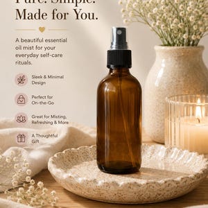 May include: A brown essential oil mist bottle with a black spray top is displayed on a textured, off-white ceramic plate. The image includes text that reads "Pure. Simple. Made for You." and "A beautiful essential oil mist for your everyday self-care rituals."
