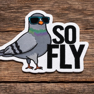 May include: Embroidered patch of a grey pigeon wearing sunglasses, with the text "SO FLY". The pigeon has a colourful neck and orange feet. The patch is set against a wooden background.