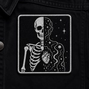 May include: A square, black and white embroidered patch featuring a half-skeleton and half-cosmic design. The skeleton side shows a skull and rib cage, while the other side depicts a starry night with a heart. The patch is bordered with white stitching.