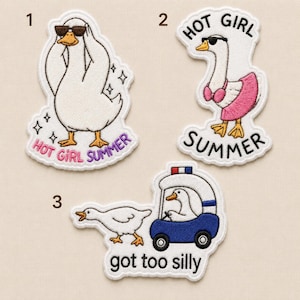 May include: Three embroidered patches featuring white geese. Patch 1 shows a goose in sunglasses with the text HOT GIRL SUMMER. Patch 2 shows a goose in sunglasses, a pink bikini top, and a pink skirt with the text HOT GIRL SUMMER. Patch 3 shows a goose driving a blue golf cart with the text got too silly.