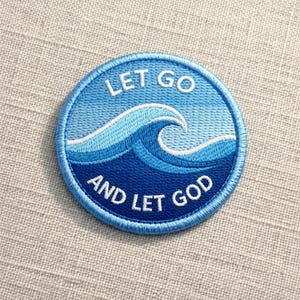 May include: Round embroidered patch with a blue wave design and the words "LET GO AND LET GOD" in white. The patch has a light blue border and is on a neutral fabric background.