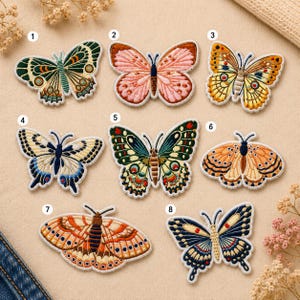 May include: A collection of eight embroidered butterfly patches in various colors and designs. The patches feature detailed stitching and a white border. Colors include green, pink, yellow, blue, and orange. These patches are ideal for adding a decorative touch to clothing or accessories.