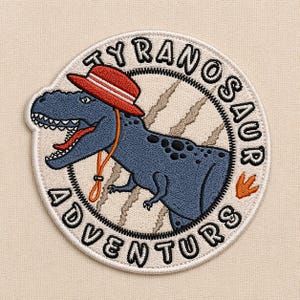 May include: Embroidered patch featuring a blue Tyrannosaurus Rex wearing a red and white hat. The dinosaur is inside a circular design with the words "TYRANOSAUR ADVENTURES" in black lettering. An orange footprint is also included.