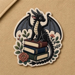 May include: Embroidered patch featuring a black dragon perched atop a stack of three books. The dragon has dark wings and is surrounded by floral elements in shades of green, red, and pink. The patch has a white border.