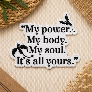 May include: White embroidered patch with black text that reads "My power. My body. My soul. It's all yours." Features two black dragon silhouettes. The patch has a white border.