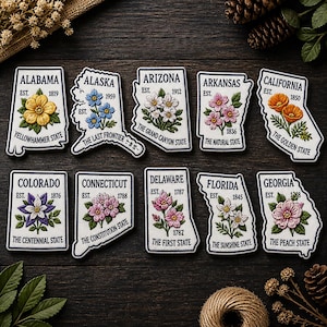 May include: Embroidered patches in the shape of U.S. states, each featuring a state flower and the state's name. Includes Alabama, Alaska, Arizona, Arkansas, California, Colorado, Connecticut, Delaware, Florida, and Georgia.