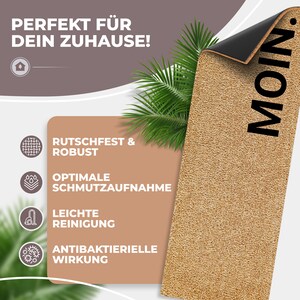 May include: A beige doormat with the word "MOIN" printed in black. The doormat has a non-slip backing and is designed to absorb dirt and moisture. It is also advertised as being easy to clean and having antibacterial properties.