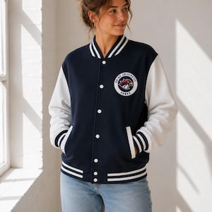 May include: A navy blue varsity jacket with white sleeves, featuring a circular patch on the left chest that reads Briar University Hawks with a hawk graphic. The jacket has a snap-button front, two side pockets, and white striped ribbed trim.