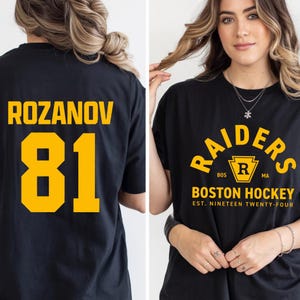 May include: Black t-shirt with "RAIDERS" in yellow arched text, a yellow "R" logo, and "BOSTON HOCKEY" below. The back of the shirt displays "ROZANOV" and the number "81" in yellow.
