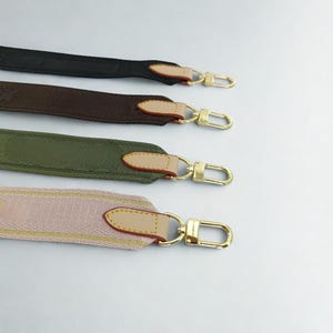 Puede incluir: Cuatro correas de bolso coloridas en negro, marr&oacute;n, verde oliva y rosa con herrajes dorados. Cada correa tiene un acento de cuero y un cierre dorado. Las correas se muestran sobre un fondo blanco.
