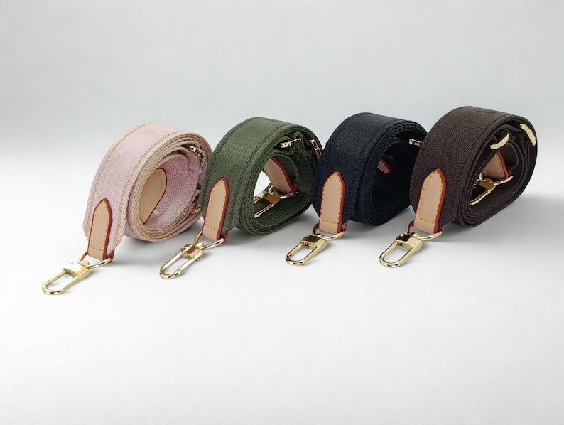Puede incluir: Cuatro correas ajustables para bolsos en rosa, verde oliva, negro y marr&oacute;n. Cada correa presenta herrajes met&aacute;licos dorados, incluidos cierres y anillos, y detalles de cuero. Las correas est&aacute;n enrolladas, mostrando su textura y color.