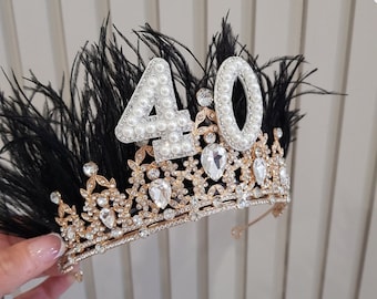 May include: A gold crown with black feathers and a white pearl-encrusted number 40 on top.