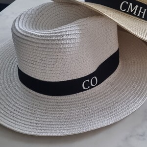 May include: White straw hat with a black band and white embroidered initials "CO".