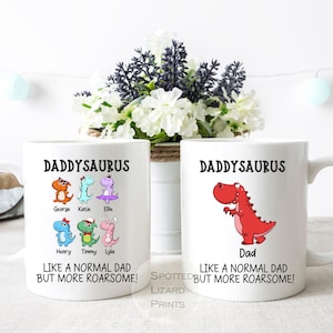 Puede incluir: Dos tazas de cerámica blanca con el texto "DADDYSAURUS" e ilustraciones de dinosaurios. Una taza presenta un dinosaurio rojo y la palabra "Dad". La otra taza tiene varios personajes de dinosaurios y nombres. Las tazas dicen "LIKE A NORMAL DAD BUT MORE ROARSOME!"