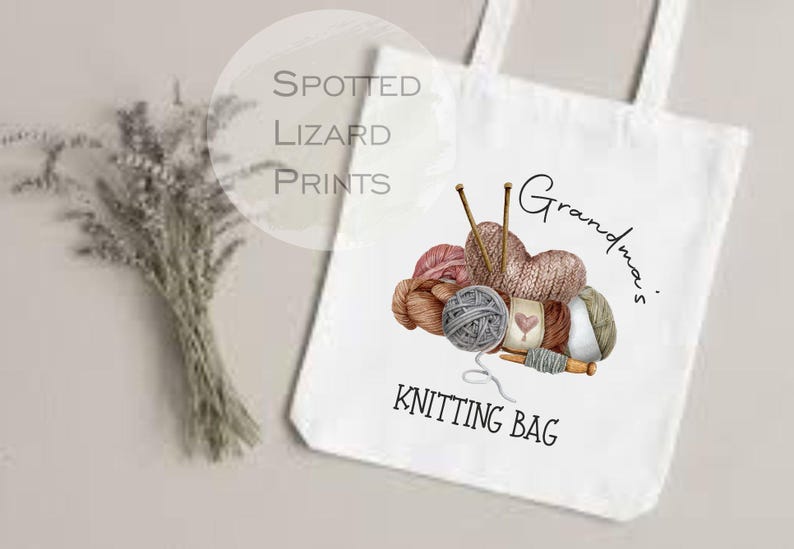 May include: White tote bag with a watercolor illustration of yarn balls, knitting needles, and the words "Grandma's Knitting Bag." The bag has a simple design, perfect for carrying knitting supplies.