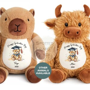 Op de afbeelding: Twee pluche knuffels, een beige beer en een harige bruine hooglander, elk met een wit buikvlak bedrukt met een aquarel teddybeer met een afstudeerhoed, de tekst Happy Graduation Day, een naam en het jaartal 2026.