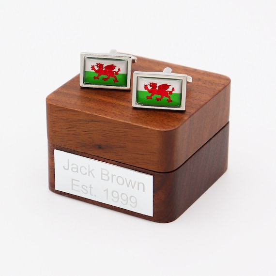 Welsh Dragon cufflinks in a walnut box with custom engraving — deeply specific cultural pride that's nearly impossible to find in a regular store.