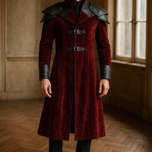 Puede incluir: Un abrigo de terciopelo burdeos con detalles de cuero negro en los hombros y los puños. El abrigo presenta un cuello alto, dos cierres de hebilla y un diseño largo y fluido. La persona lleva pantalones y botas negras.